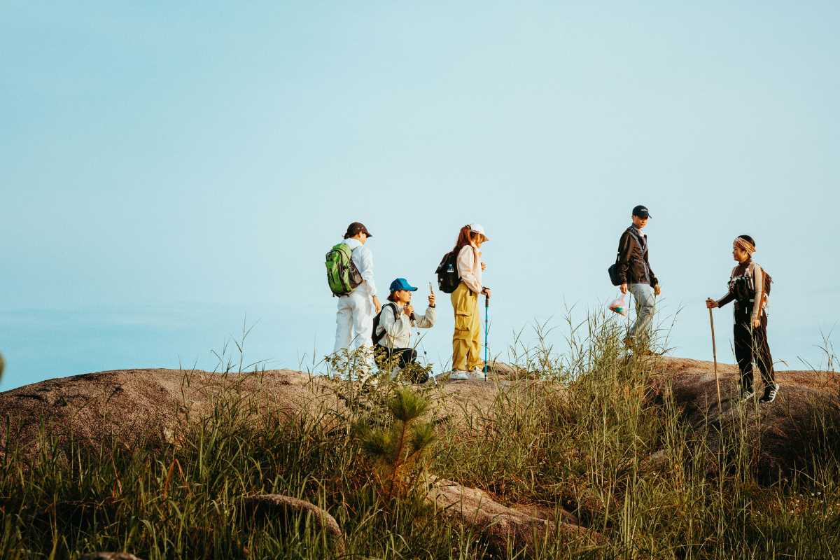 Famiglia con bambini lungo il sentiero nel bosco vicino a Orvieto, atmosfera primaverile, zaini da trekking